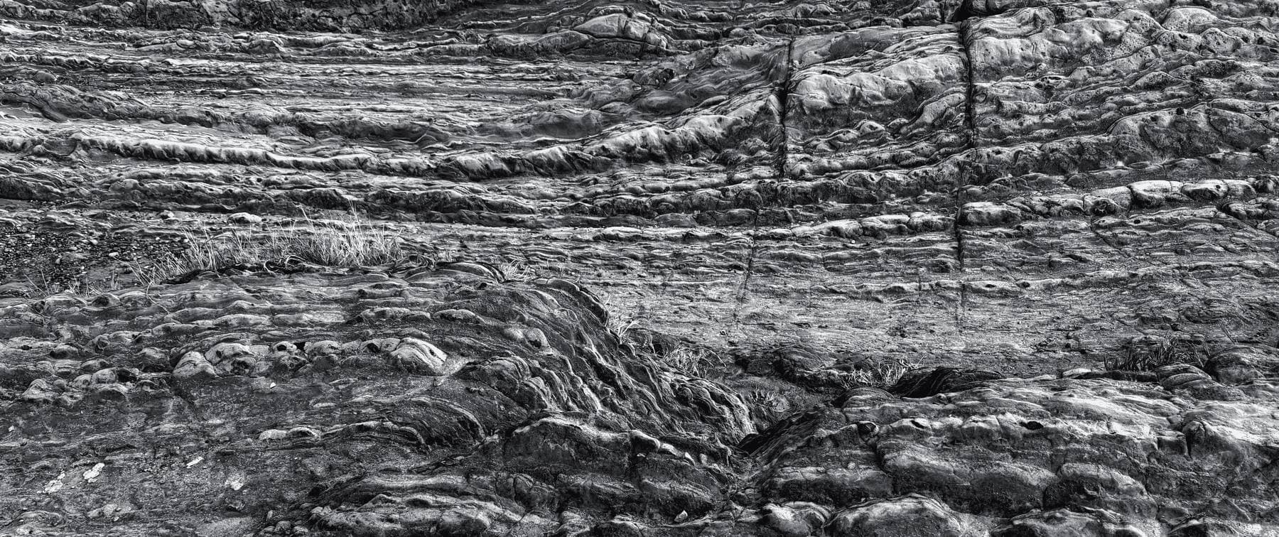 Layered sedimentary rock strata in black and white