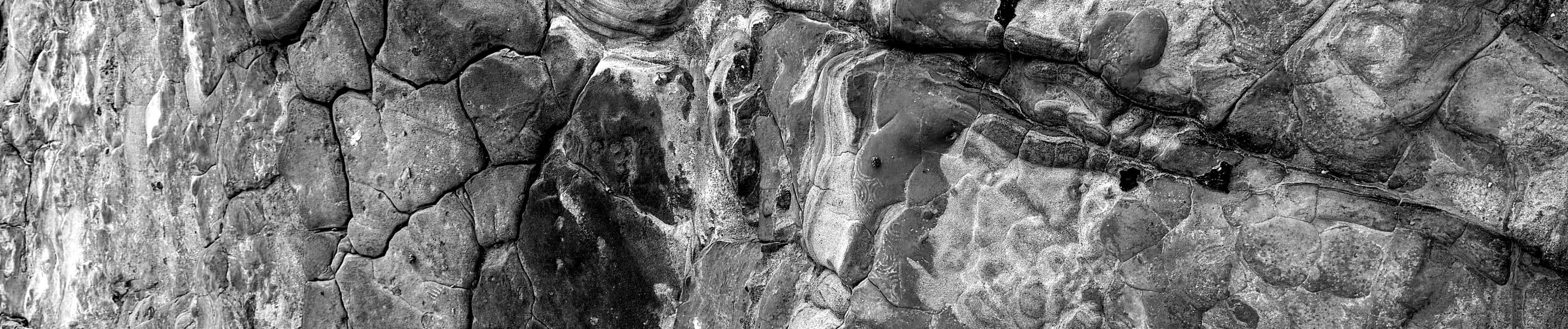 Fractured coastal rock, black and white